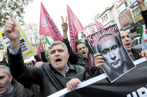 T06 ESTAMBUL (TURQUÕA), 27/11/2015.- Manifestantes turcos gritan consignas contra Rusiamientras sostienen una pancarta con una fotografÌa del presidente ruso, VladÌmir Putin, durante una protesta en Estambul, TurquÌa, hoy, 27 de noviembre de 2015. El primer ministro turco, Ahmet Davutoglu, ha seÒalado que TurquÌa trabajar· con Rusia para rebajar la tensiÛn por el derribo de un aviÛn militar ruso el pasado 24 de noviembre y ha indicado que la prioridad debe ser luchar contra el Estado Isl·mico (EI). EFE/TOLGA BOZOGLU